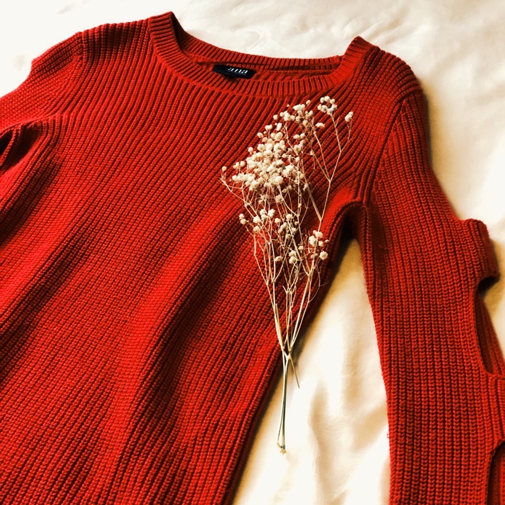 Red knit sweater with cut details on the sleeves